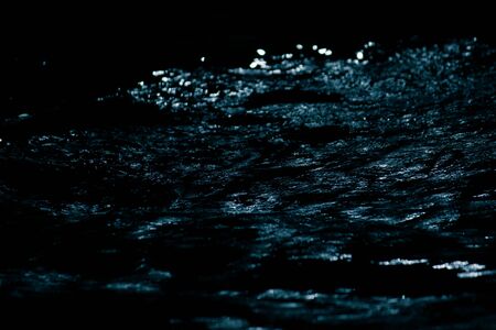 The beautiful view of fresh river stream water slowly flowing through natural rock beach at night in countryside, Thailand. Abstract nature background.の写真素材