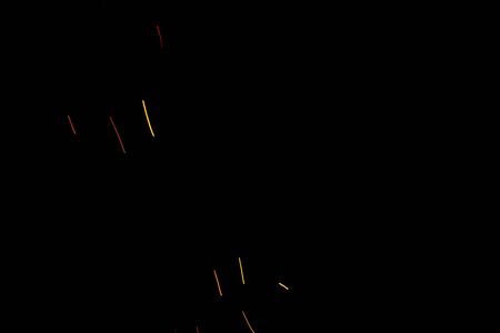 Burning red hot flying with sparks in the night sky. Beautiful abstract background of fire sparks particles on black background.の写真素材