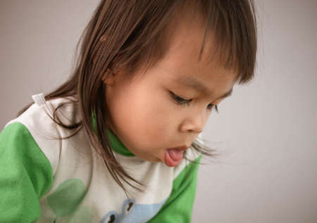 Cute little girl coughing isolated on gray background. Concept of healthcare and medical in child.