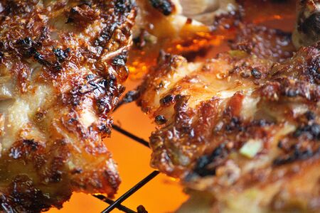 Grilled chicken thigh on the flaming grill.の写真素材