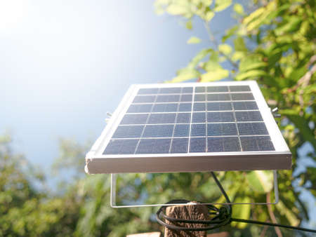 Small solar panels set on outdoor poles on a sunny day. Mini solar panel for LED spotlight in the garden.の写真素材