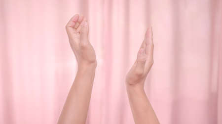Hands applauding isolated on pink background. Isolated female hands applauding symbol of appreciation. Sign language.の写真素材
