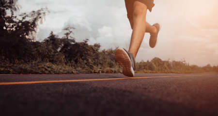 Teenage boys runner running on the street for exercise. Close up of legs. Healthy lifestyle concept.の写真素材