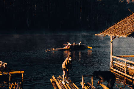 Mae Hong Sorn, Thailand - December 17, 2021 : Beautiful lake over the misty river at sunrise with traveler on the Bamboo raft. Morning view at Pang Oung Lake (Pang Tong reservoir), Mae hong son, Thailのeditorial素材
