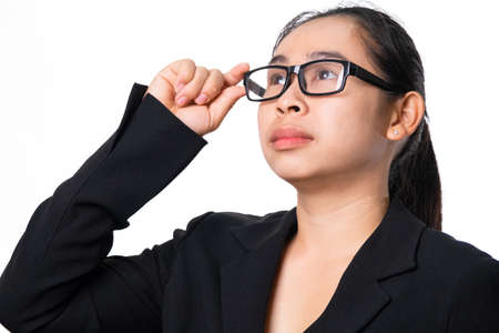 Confident Asian businesswoman looking up on white background in studioの写真素材