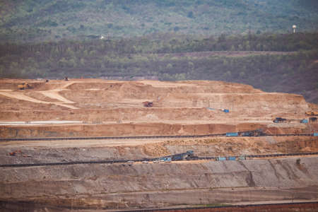 View of Trucks and excavators work in open pits in lignite coal mines. Lignite Coal Extraction...