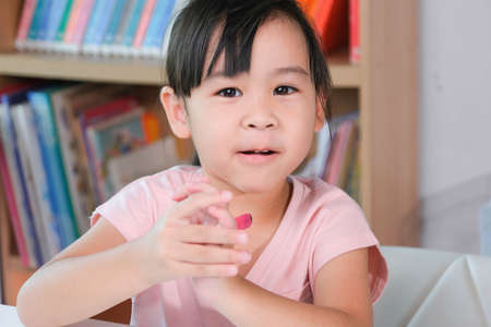 Cute little girl taking lessons for home schooling. Portrait of a cute girl looking at the camera...