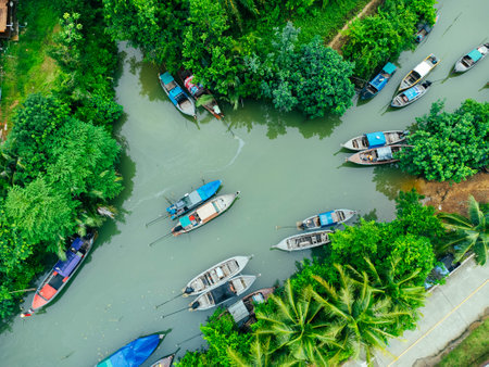 Aerial view from drones of fisherman boats and harbour in the river near the Andaman Sea in southern Thailand. Top view of many Thai traditional longtail boats floating in the mangrove landscape.の写真素材