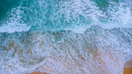 Beautiful sea waves and white sand beach in the tropical island. Soft waves of blue ocean on sandy beach background from top view from drones. Concept of relaxation and travel on vacation.の写真素材