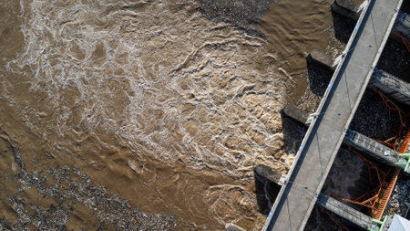 Aerial view of water released from the drainage channel of the concrete dam is a way of overflowing...