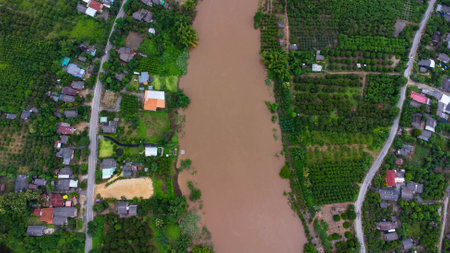 Aerial view of the river flowing after heavy rain and flooding of fields in rural villages. Top view...