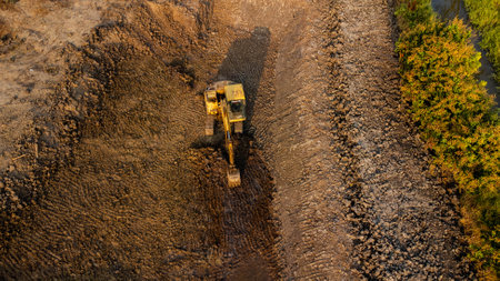 Aerial view of wheel loader excavator with backhoe unloading sand in construction site.の写真素材