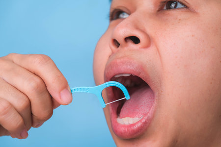 Close-up of smiling asian woman and cleaning for perfect smile. Healthy white teeth by flossing, oral health and dental care.の写真素材