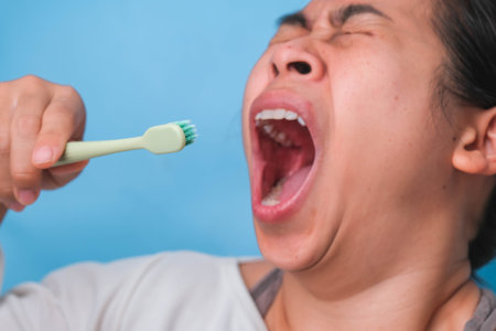 Yawn woman wake up with tooth brush on blue background. Oral care concept.の写真素材