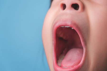 Close-up inside the oral cavity of a healthy child with beautiful rows of baby teeth. Young girl opens mouth revealing upper and lower teeth, hard palate, soft palate, dental and oral health checkup.の写真素材