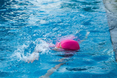 Little girl practicing swimming in the pool. Happy children swimming and playing in the water. summer vacation concept.の写真素材
