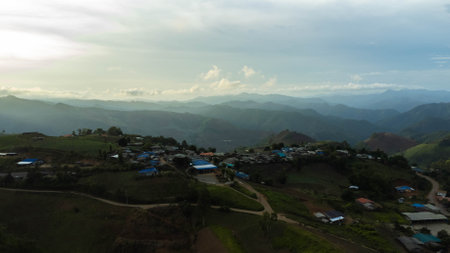 Aerial view of beautiful sunrise or sunset sky and rural villages. Village landscape in misty valley and mountain clouds in thailand.の写真素材