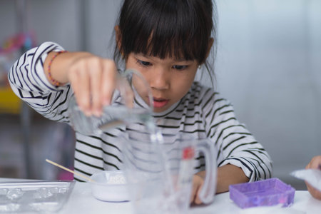 Cute little girl making DIY plaster and painting at home. Children paint on plaster sculptures with family on holiday. Imagination and creativity activities.の写真素材