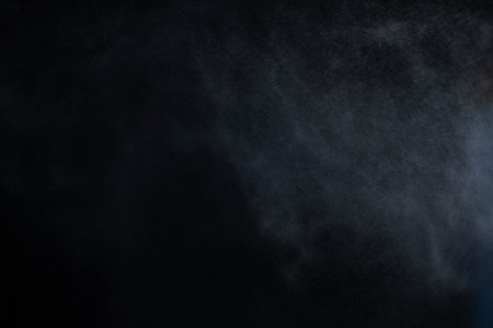 Water spray dust on dark background. Spraying mist effect isolated on black background.の写真素材