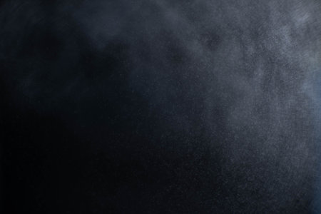 Water spray dust on dark background. Spraying mist effect isolated on black background.の写真素材