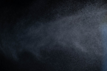 Water spray dust on dark background. Spraying mist effect isolated on black background.の写真素材