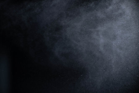 Water spray dust on dark background. Spraying mist effect isolated on black background.の写真素材