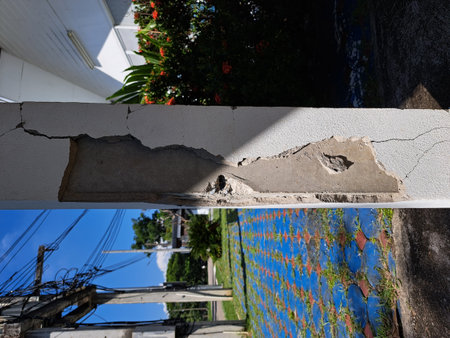 Cracks in damaged building pillars. Cracked concrete pillar of an old house. Deep and clear fractures, on the front surface of an old cement pillar.の写真素材