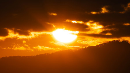 Closeup of bright big sun on the sky with orange gradient colors in a calmly evening.の写真素材