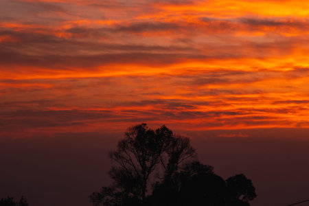 Beautiful nature morning with orange, yellow sunshine and fluffy clouds. Beautiful colorful dramatic sky with clouds at sunset or sunrise.の写真素材