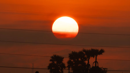 Beautiful nature morning with orange, yellow sunshine and fluffy clouds. Time lapse of a beautiful dramatic sky with a big sun at sunrise.の写真素材