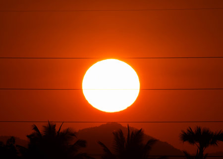 Beautiful nature morning with orange, yellow sunshine and fluffy clouds. Time lapse of a beautiful dramatic sky with a big sun at sunrise.の写真素材