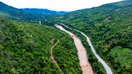 Aerial view of the mighty Mekong River meandering in the morning during the rainy season against the lush green mountains.の写真素材