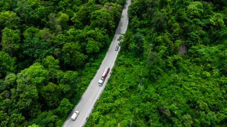 Aerial view of countryside asphalt road with car and green forest. Drive on the road between green forests.の写真素材