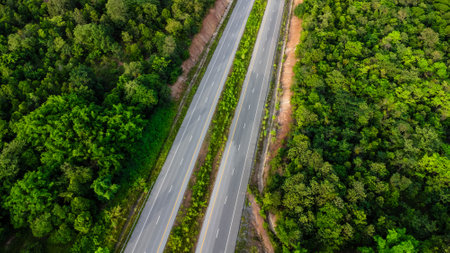 Aerial view of countryside asphalt road with car and green forest. Drive on the road between green forests.の写真素材