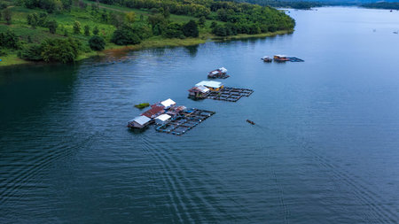 Aerial view of the River Kwai and floating houses in Kanchanaburi Province, Thailand. Beautiful view of floating cottages and Thai long-tail boats sailing on the River Kwai.の写真素材