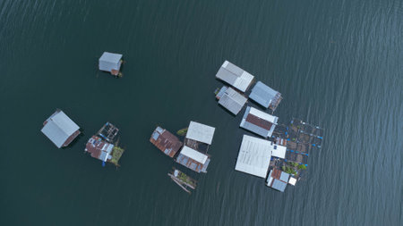 Aerial view of the River Kwai and floating houses in Kanchanaburi Province, Thailand. Beautiful view of floating cottages and Thai long-tail boats sailing on the River Kwai.の写真素材