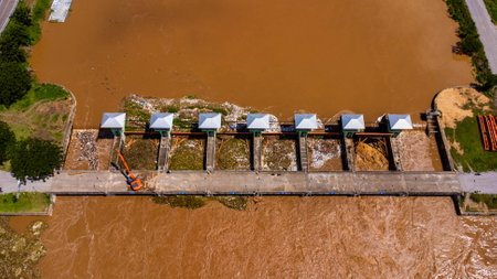 Aerial view of the dam's floodgates with rapid flow of water in the rainy season. Dam water release, dam overcapacity after heavy rain.の写真素材