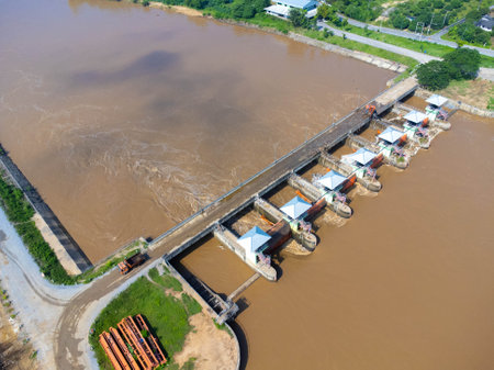 Aerial view of the dam's floodgates with rapid flow of water in the rainy season. Dam water release, dam overcapacity after heavy rain.の写真素材