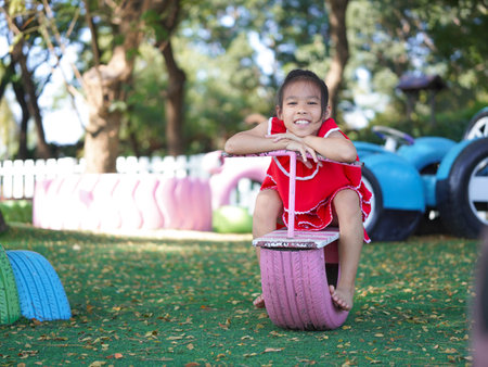 Cute girl playing in the playground during summer vacation. Happy children having fun in an outdoor park.の写真素材