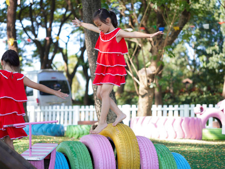 Cute girl playing in the playground during summer vacation. Happy children having fun in an outdoor park.の写真素材