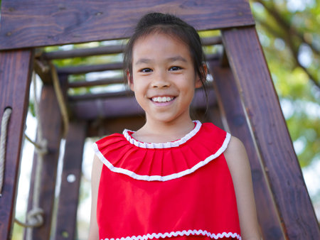 Cute girl playing in the playground during summer vacation. Happy children having fun in an outdoor park.の写真素材