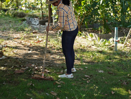 Asian adult woman working outdoors in summer garden.の写真素材