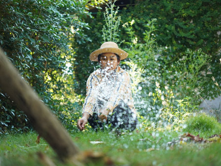Asian adult woman working outdoors in summer garden.の写真素材