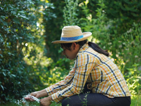 Asian adult woman working outdoors in summer garden.の写真素材