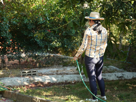 Asian adult woman working outdoors in summer garden.の写真素材