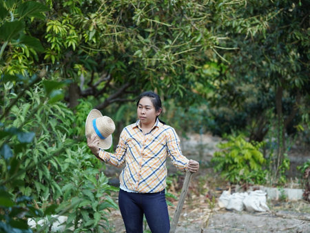 Asian adult woman working outdoors in summer garden.の写真素材