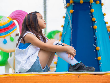 Asian girl having fun in amusement park, enjoying carousel on family vacation.の写真素材