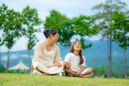 Happy mother and daughter spending time together in a park during spring.の写真素材