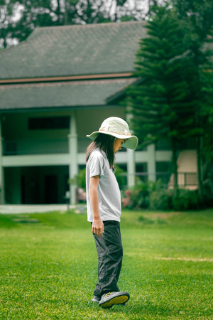 A happy little girl is exploring the grass and looking around. Adventure tourism and learning concept.の写真素材