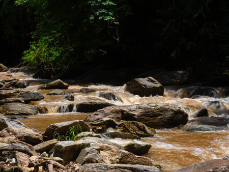 The nature of the waterfall in the forest that flows strongly during the rainy season. Strong current in the river, waters turned muddy after heavy rains in autumn.の写真素材